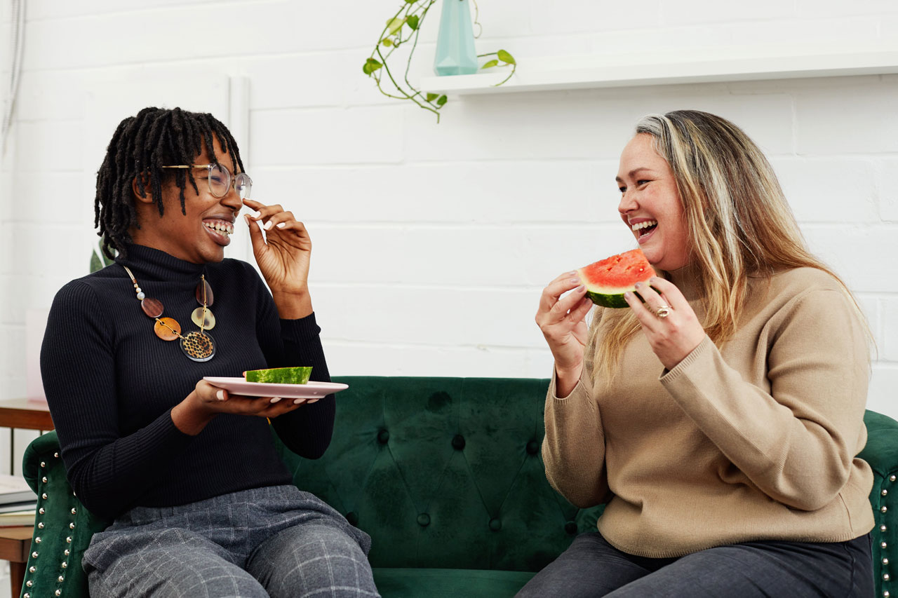 Femmes Deux femmes assises sur un divan et discutant